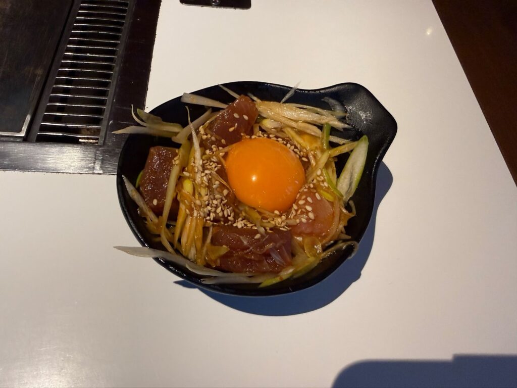 飲食店の店内照明のみで撮影し料理の色がくすみ強い影が出ている失敗例