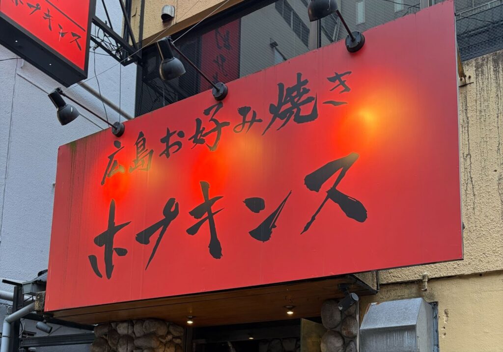 撮影協力店舗である広島お好み焼きホプキンス立川店の外観と赤い看板