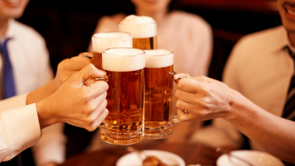 居酒屋でビールジョッキを傾けて乾杯する様子（居酒屋向けPOSレジおすすめ比較）
